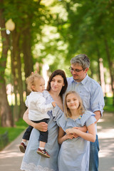 Fototapeta na wymiar Happy family with two kids in the park