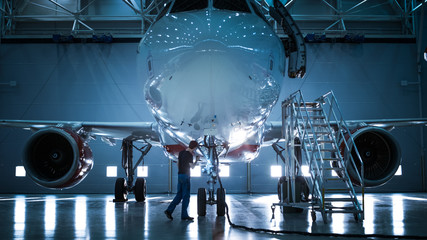  Brand New Airplane Standing in a Aircraft Maintenance Hangar while Aircraft Maintenance Engineer/...