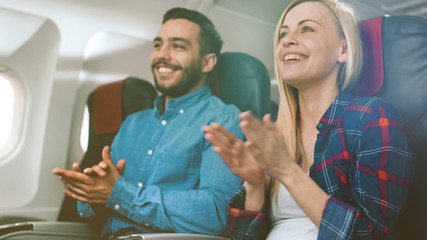 On Board of Commercial Airplane Beautiful Young Blonde and Handsome Hispanic Male Applauding...