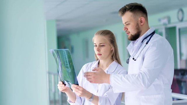 Two colleagues doctor discussing and looking at X-ray snapshot medium shot
