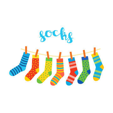 colored socks hanging on a rope on white background