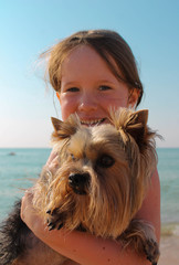 Girl with a dog on the beach by the sea