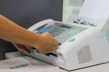 hand man are using a fax machine in the office. Business concept 
