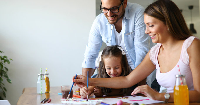 Mom and dad drawing with their daughter