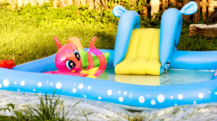 Inflatable swimming pool with children's toys in the yard