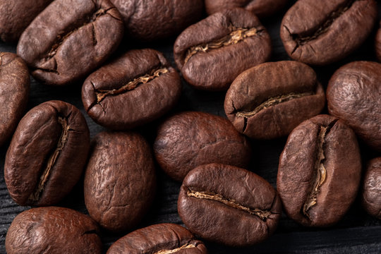 Coffee Arabica Grains Scattered On A Wooden Table