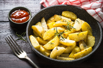 Baked potato with herbs in the pan.