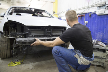 Fototapeta na wymiar professional repairman worker in automotive industry sanding plastic body car bumper