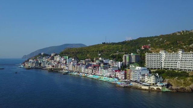 Aerial drone panorama footage of colorful cityscape on the mountains over sea, Europe, Dense multi-storey building by the sea in the resort. Crimea, Utes Ellings, Black Sea.