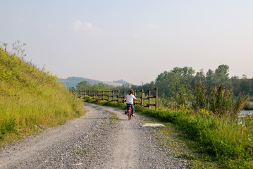 Obraz premium A little girl cycling along a path