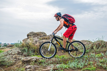 Fototapeta na wymiar Enduro Cyclist Riding the Mountain Bike on the Rocky Trail, copy of free space.