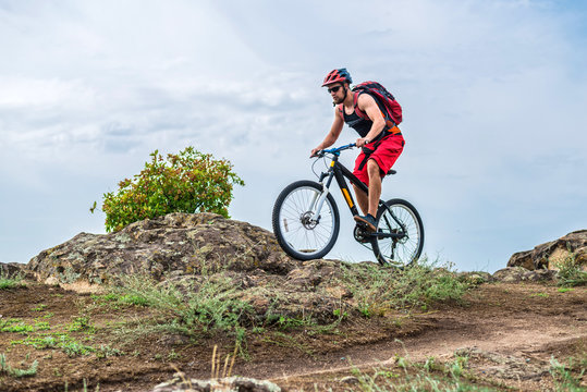 Enduro Cyclist Riding the Mountain Bike on the Rocky Trail, copy of free space.