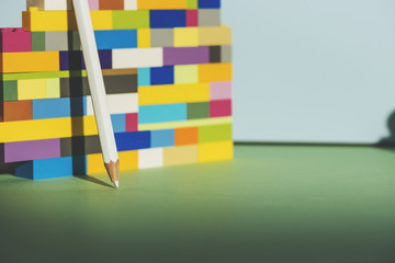 Pencil leaning against the colorful brick Back to school concept
