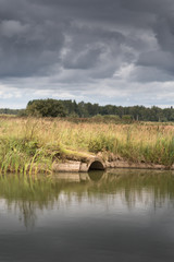 sewage from the sewer pollutes a lake or water gushing from the sewer to the river. Dark cloudy sky