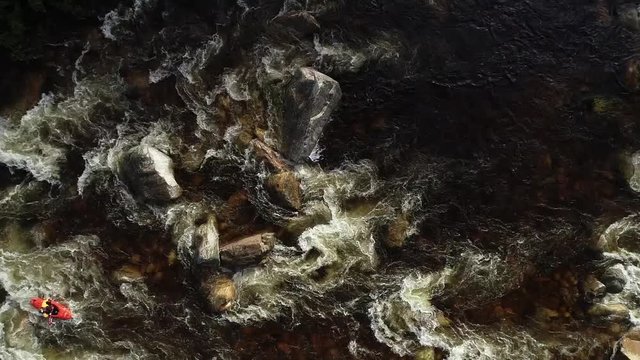 Aerial footage of white water kayaks paddling in the white water rapids on a freestone stream in the western cape of south africa during a winter storm.