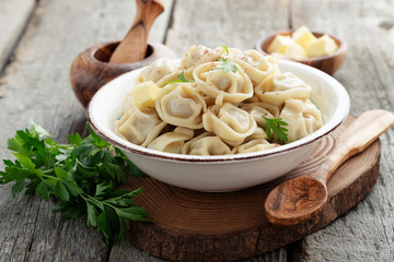Russian pelmeni meat Dumplings with butter and greens.