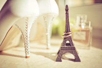Wedding shoes and wedding rings on a small eiffel tower