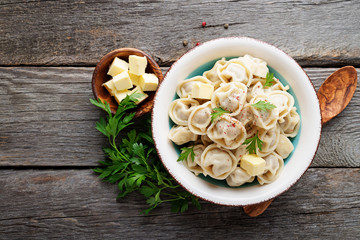 Russian pelmeni meat Dumplings with butter and greens.