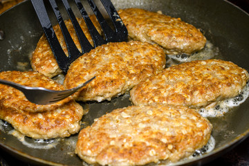 Delicious juicy homemade cutlets are cooked in a frying pan. In bubbling oil. Selective focus.
