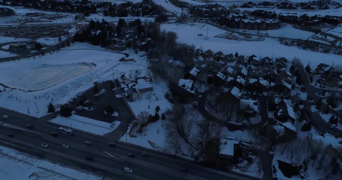 Aerial Slow move forward and pan up to reveal mountain range of par city and ski resort.