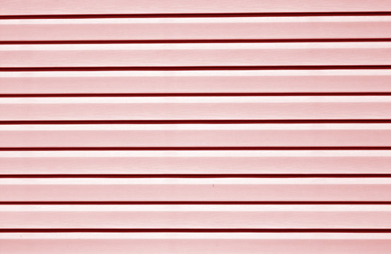 Plastic siding surface in red tone.