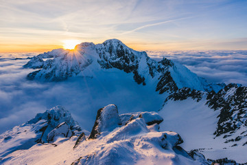 Stunning sunset or sunrise in winter alpine like snow landscape. Inversion, sun star peaking behind...
