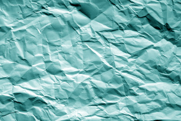 Crumpled sheet of paper in cyan tone.