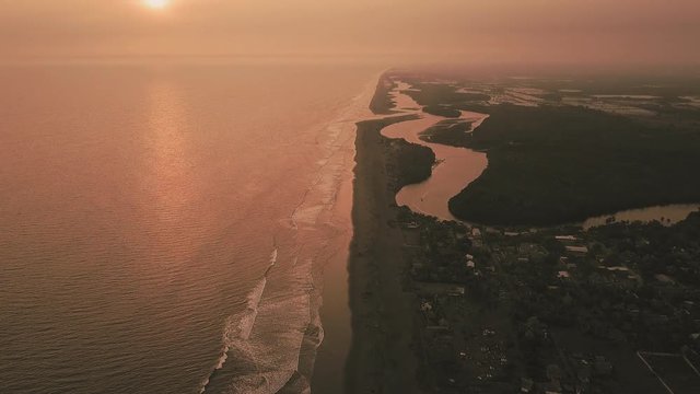 Pink sunset over Guatemala's Pacific coast at El Paredon beach, TILT SHOT
