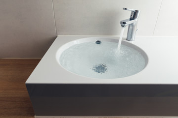 faucet with flowing water in wash sink