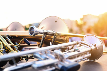 wind instruments lying on a table against a blurred background - obrazy, fototapety, plakaty