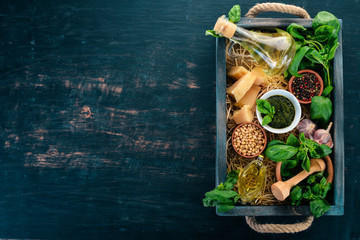 Ingredients for cooking Pesto sauce in a wooden box. Basil, parmesan cheese, olive oil, pine nuts,...