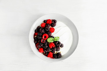 Healthy breakfast bowl of yogurt with raspberries, blackberries and muesli