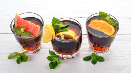 Cocktails with citrus fruit and mint. Lemon, grapefruit, lime, orange. On a wooden background. Top view.