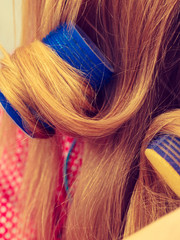 Woman curling her hair using rollers