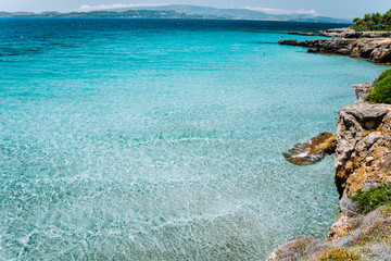 Small tranquil cove with calm shallow blue water. Cozy pine forest along the beautiful rocky costal bay. Idyllic mediterranean landscape