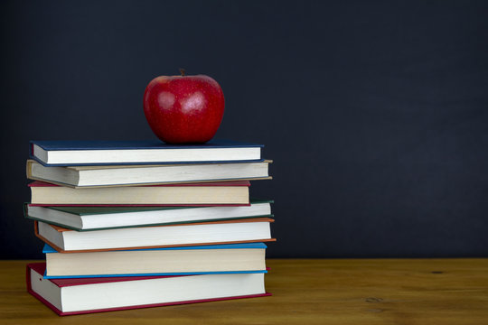 Manzana roja en libros escolares con espacio de copia en pizarra