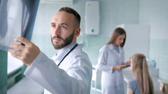 Woman meeting with team of two doctors in medical office or hospital