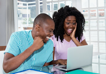 African american couple shopping presents and gifts online with laptop
