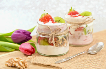Obraz na płótnie Canvas Mixed fruits and walnuts yogurt in glass with bow tie on Bokeh background..Breakfast with many kind of fruits and yogurt.
