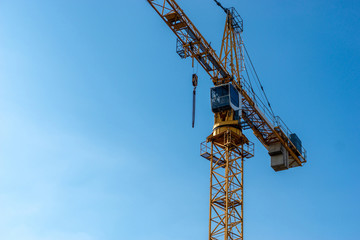Naklejka premium orange crane with blue sky in the background - copy space on the left side