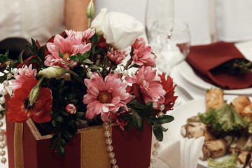 stylish red vase with flowers on table, luxury decorated place for wedding ceremony and reception