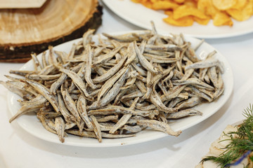 salty smoked anchovies on wooden desk on table, wedding reception. beer bar and snacks. catering in restaurant
