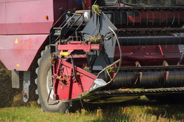 Harvesting, harvest - the rotor of red-white harvester combine close up on the field in the village...