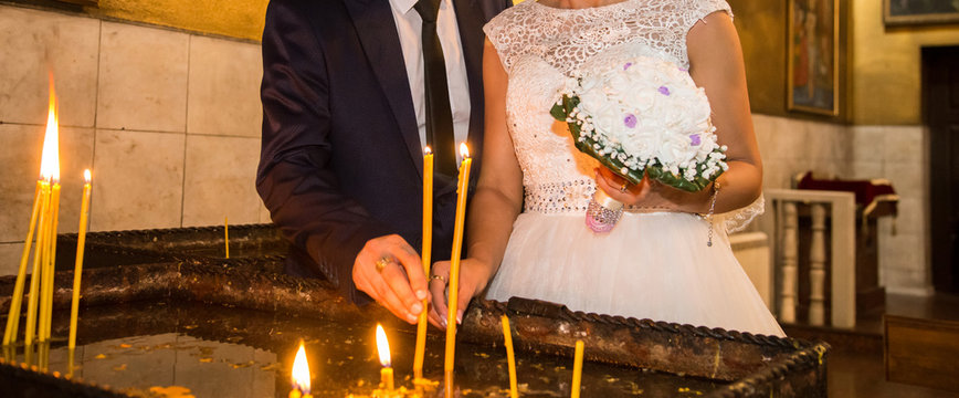 The bride and groom put candles in the church