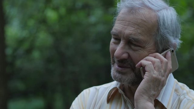 Elderly Bearded Man Talking On The Smartphone In The Forest