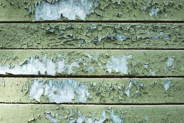 peeling paint on the wooden surface of the wall