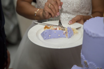 Obraz na płótnie Canvas Bride is trying a wedding cake