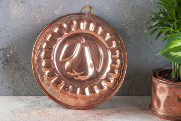 Vintage copper mold on a concrete background.