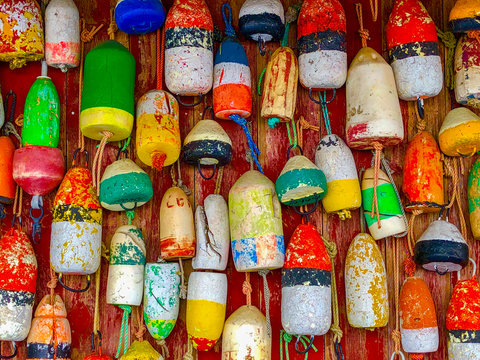 Wooden wall covered with many colorful buoys