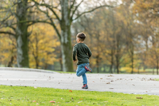 Young boy running in autumn park